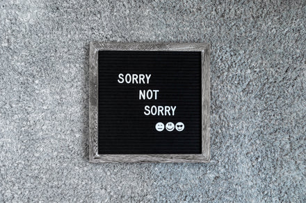 A black felt letter board (on a grey carpet background) that says 